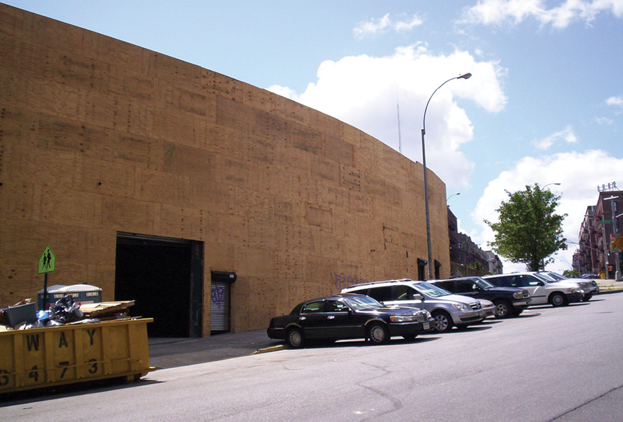 The entire building is wrapped in plywood then polystyrene insulation; the large casement windows in the rear on the second floor are now covered.