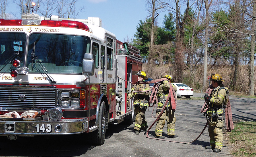 Together, the nozzle firefighter and the backup firefighter (the nozzle team) proceed toward the entry point of the fire building