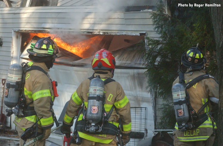 Firefighters and flames venting from garage