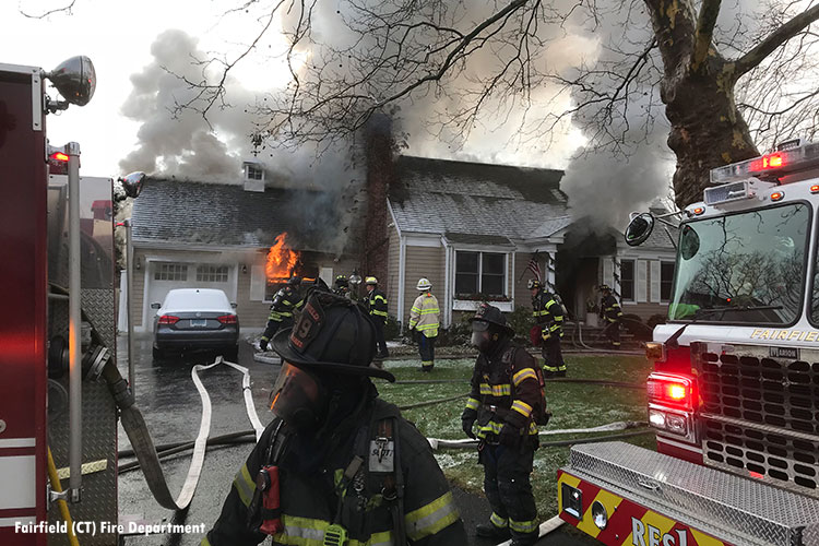 Firefighters stretch hose at house fire