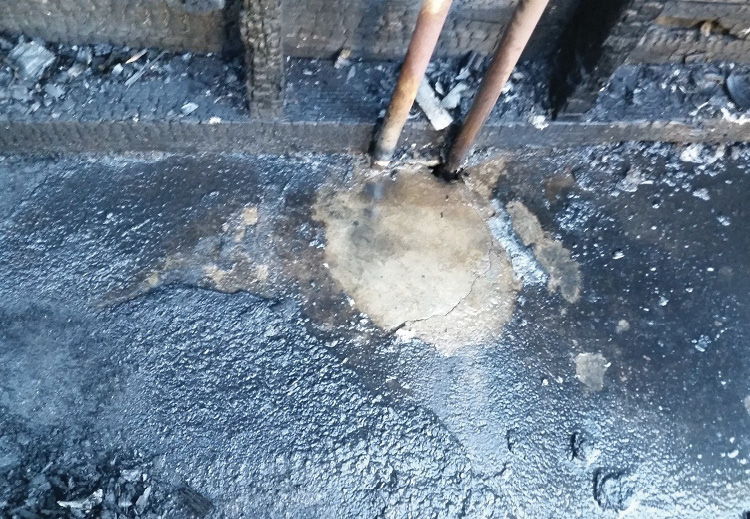 The plastic bag of rock salt sat in the uncharred area, where the remains of the plastic bag protected the floor.