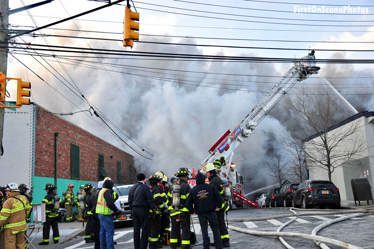 FDNY members and tower ladder working at Queens fire