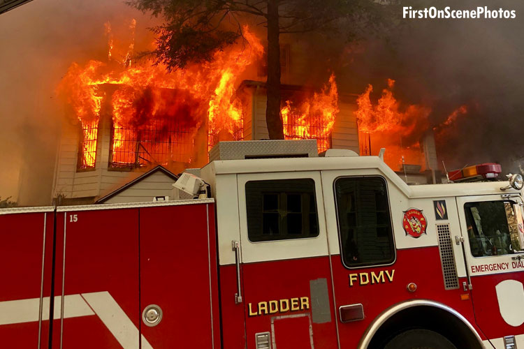 Fire truck in front of a raging house fire