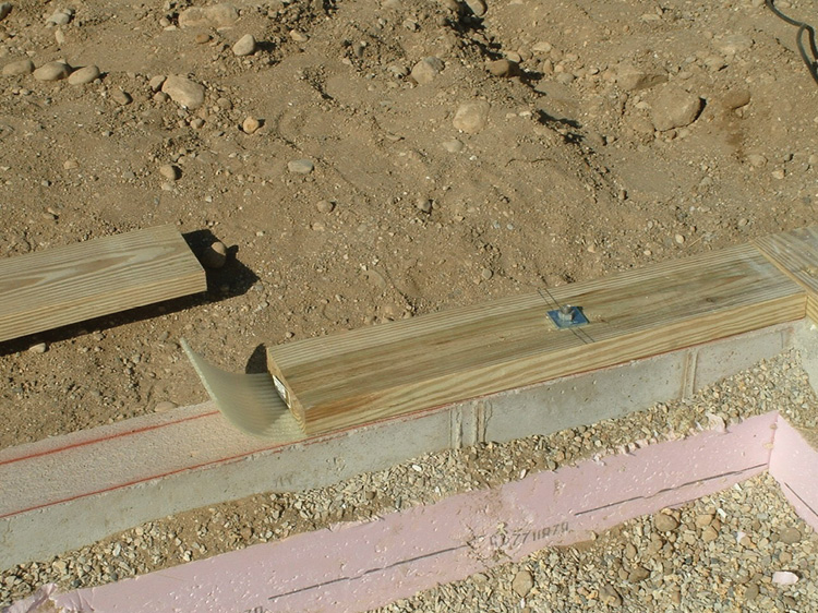 A sill plate on concrete, a 2- × 6-inch PT wooden plate with bolts anchoring it to a reinforced concrete foundation. (Photo by Gregory Havel.)