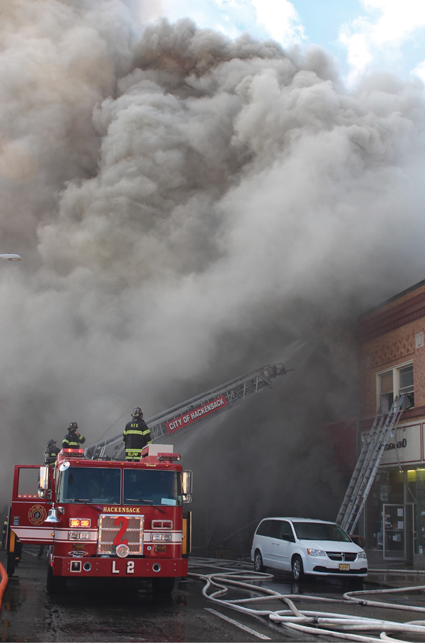 The burning mattresses and furniture produced a very heavy smoke condition, which was fanned by 20 mile-per-hour northwest winds. The first-due ladder was later repositioned to allow for master stream use. (Photo by Ron Jeffers.)