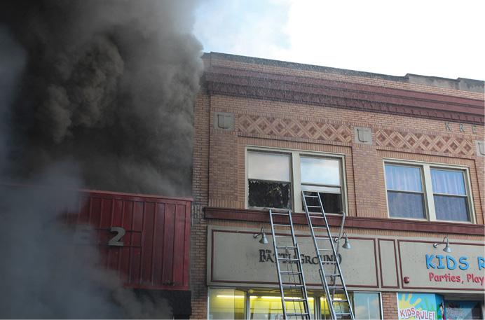 Firefighters operate in exposure D, into which the fire did not extend. The structure sustained heavy damage in the rear because of a collapsed wall from the original fire building. (Photo by Ron Jeffers.)