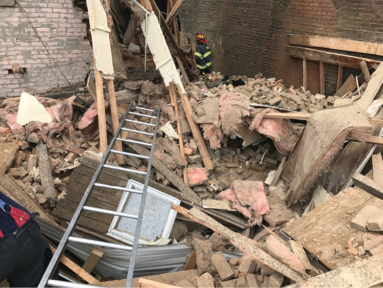 This ladder was used as a bridge across the collapsed roof rubble between the back of the C side (at left) and exposure B side (at right). This was the initial access path to the victim. (Photo by Christopher Chiprich.)