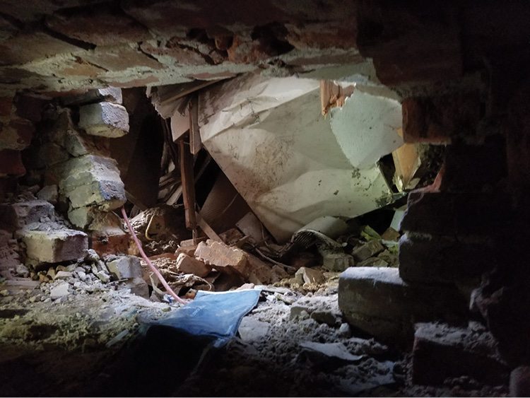 A view of the collapse through the B exposure access after the operation. Spreaders and air bags were initially used to attempt to push/displace the refrigerator and the structural members. They failed to move the structural members or the refrigerator and were used only as supportive devices. (Photo by Jeffrey Yates.)