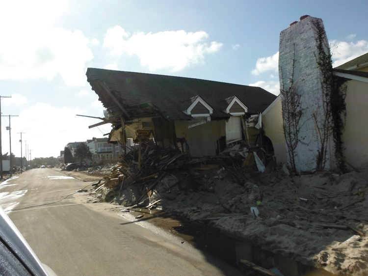 (2) This rooftop was all that was left of a house after Super Storm Sandy. The weather and the destruction of many structures and the transportation infrastructure complicated the rescue. 