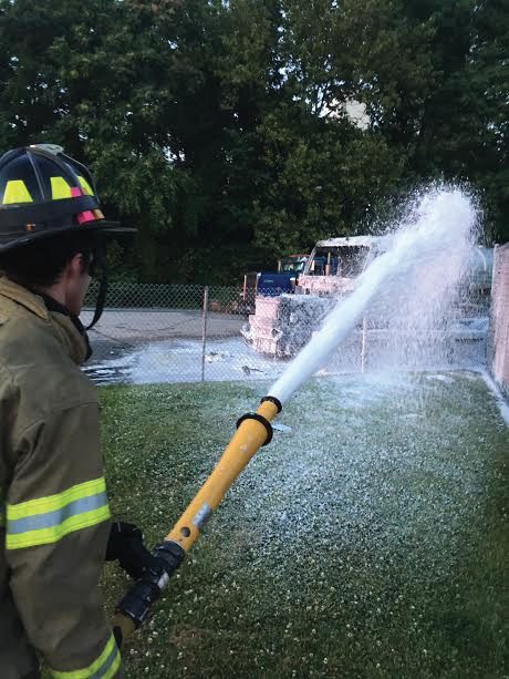 (5) A King of Prussia (PA) firefighter uses foam to extinguish a diesel fire involving a bobtail tractor trailer truck. Several exposures were protected with water until the foam arrived. The running diesel fire spread to a nearby compactor but was stopped by using an oil absorbent before the fire reached a nearby building. Improvise, adapt, and use what you have in your arsenal to stop these fires from reaching any threatened exposures.