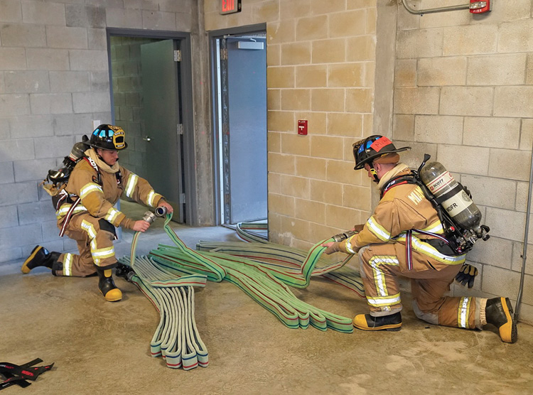 Connecting three 75-foot bundles. Notice that the female couplings are facing the source of the water and the standpipe outlet is in the stairwell.