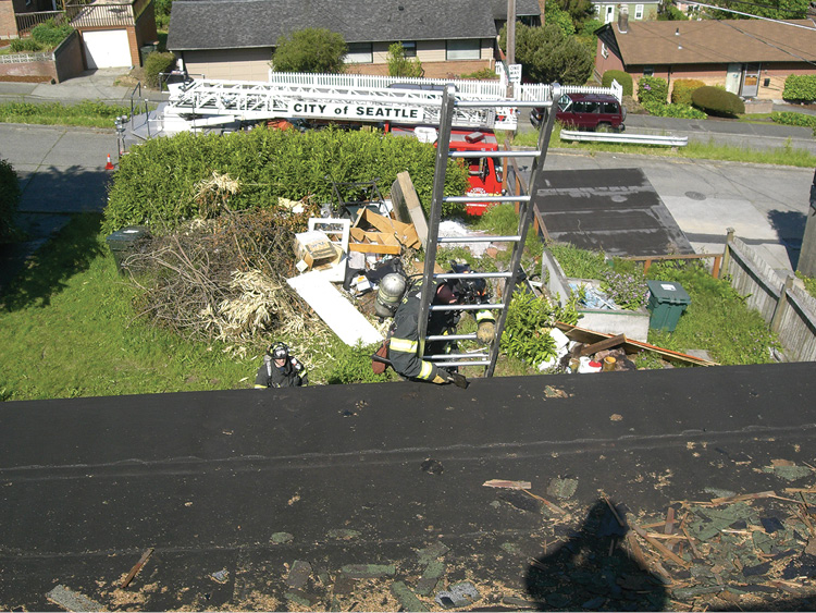 (2) The students are arriving at the transition from the ladder to the roof of an acquired structure training site. The instructor should be in position on the roof before the students arrive. (Photo courtesy of Seattle’s Bravest Charity.)