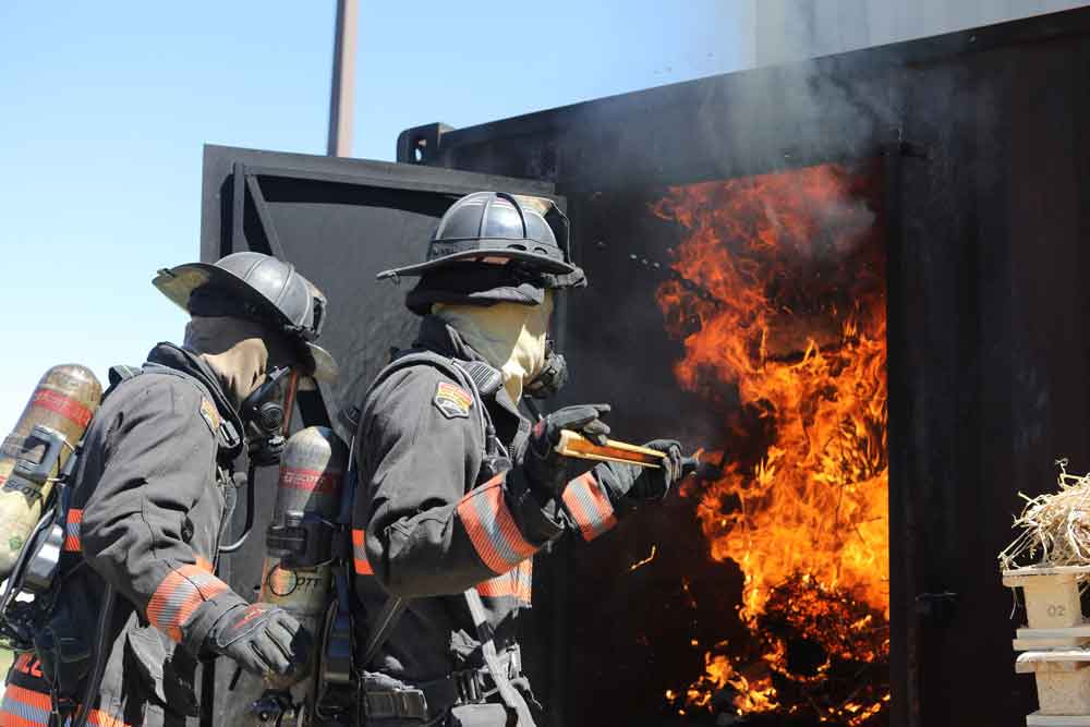 Firefighters stoking flames in the flashover can