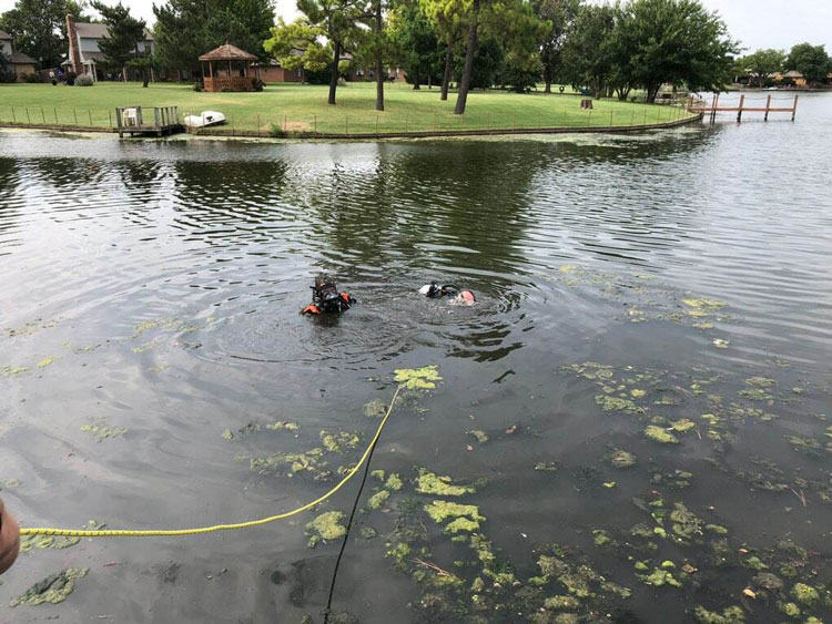 Fire department divers operate in a pond