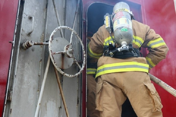 Firefighter with a hoseline on a ship