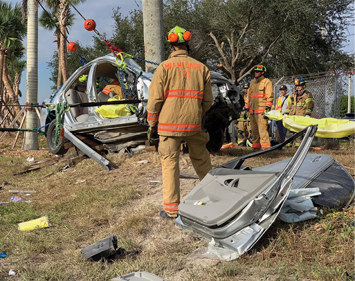 The wire ropes from all five winches are being tensioned in unison—two winches maintaining the levelness of the vehicle (tensioned vertically); two winches pulling the vehicle away from the tree (tensioned horizontally); and one winch, on the driver’s side of the vehicle, used as the control line (with yellow cover), positioned opposite the rotator. Note the spotters at all the critical points/areas of the operation.