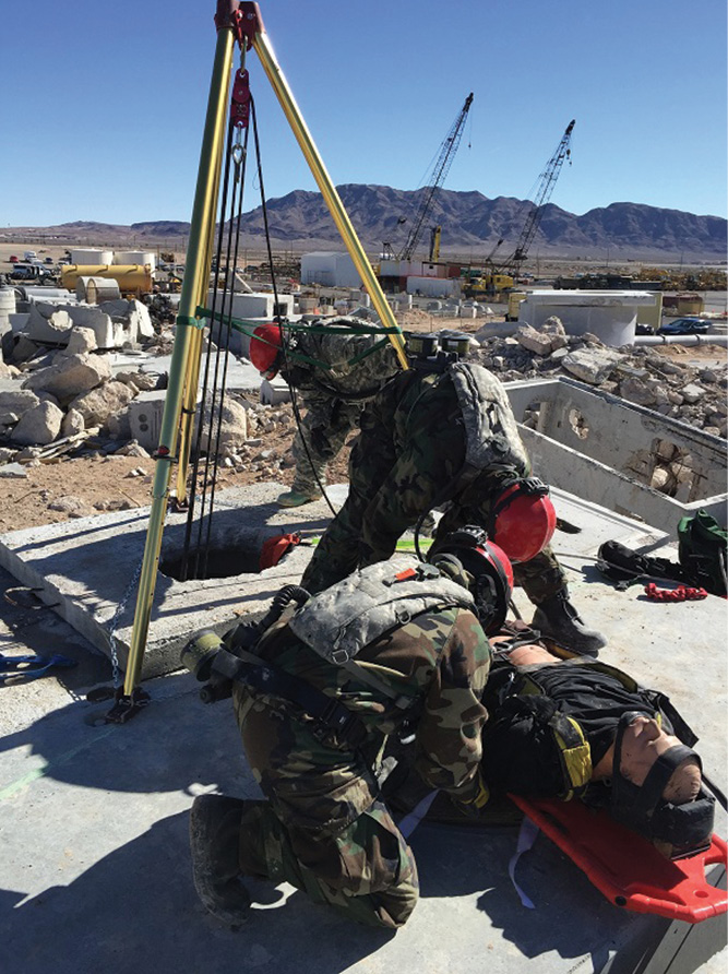 Rescuers use a tripod to extract the victim from a lower level. 