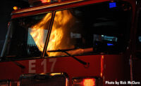 Fire reflected on the windshield of an apparatus.