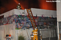 Firefighters ladder a building on the fireground.