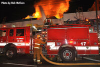 Firefighter working the pump panel of an apparatus on scene.