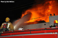 A firefighter directs a stream onto the flames.