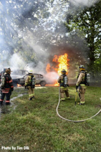 Firefighters operate a hoseline at a garage fire with extension.