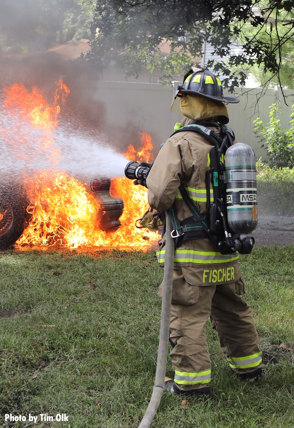 Another photo of a firefighter with a hoseline putting water on the fire.