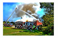 Aerial streams are directed on the burning building.