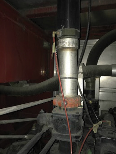 The path that water takes from the pump to the deck gun. From bottom to top: pump discharge manifold, discharge control valve, and discharge pipe. The pressure tap is the brass-colored, right-angle fitting just above the joint between the silver and black vertical pipes. The red plastic hose transmits the water pressure to the gauge on the pump panel. On this pumper, the pressure tap for the deck gun is in a straight, large-diameter pipe directly below the base of the monitor, so the majority of the postgauge friction loss will be in the monitor.