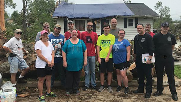 Roving crews take a minute to get a photo with survivors and volunteers during recovery operations. (Photo by Andrew Mallow.)