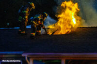 Flames vent from the roof after crews open a vent hole.