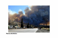 A giant plume of smoke hangs over the road