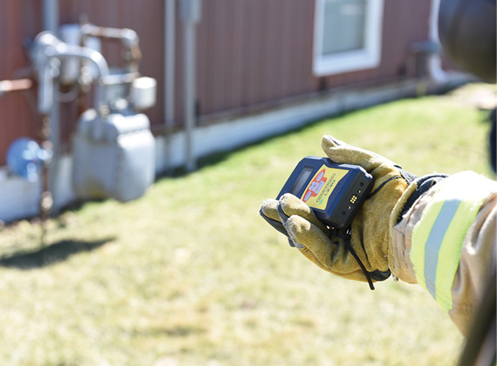 A firefighter points the handheld laser gas detector at a commercial meter to determine if gas is leaking.