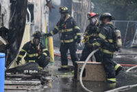 Firefighters with a handline at the scene of the fire