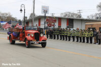 Old fire apparatus makes its way down the route during the funeral