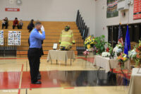 A firefighter salutes his fallen colleague