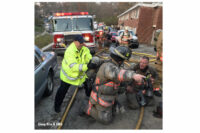 A firefighter gestures to another on scene.