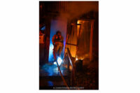 A firefighter advances a hoseline into the structure.