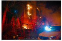 Firefighters advance a line into the burning building.