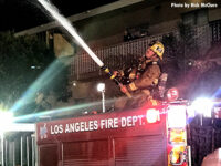 A firefighters operating a stream at the fire in the vacant.