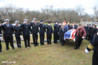 The casket is hauled to its final resting place.