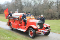 An old fire apparatus bearing the casket.