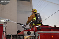 A firefighter aims a deck gun at the building.