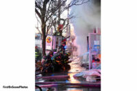 Firefighters control a hose stream.