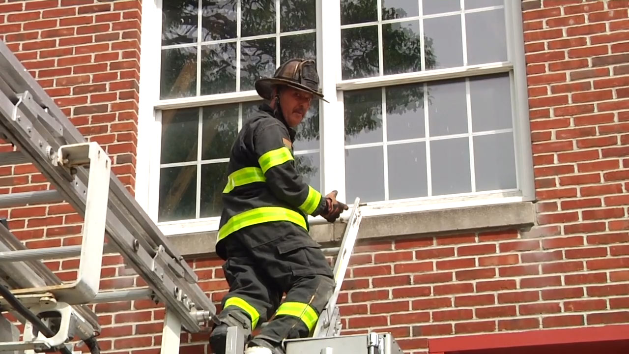 Mike Ciampo on extension ladder mounted on tower ladder