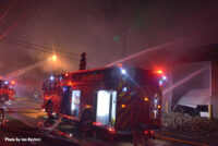 Firefighter on a Dearborn fire truck monitoring a stream