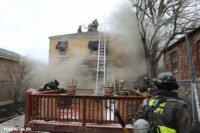 Firefighters work on the roof during the fire