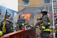 Flames roar inside the structure as firefighters work to control them.