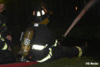 A firefighter controlling a line at the scene