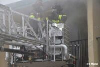 Firefighters in tower ladder bucket at motel fire